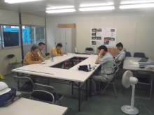 現場事務所で安全パトロールの結果報告をしています。